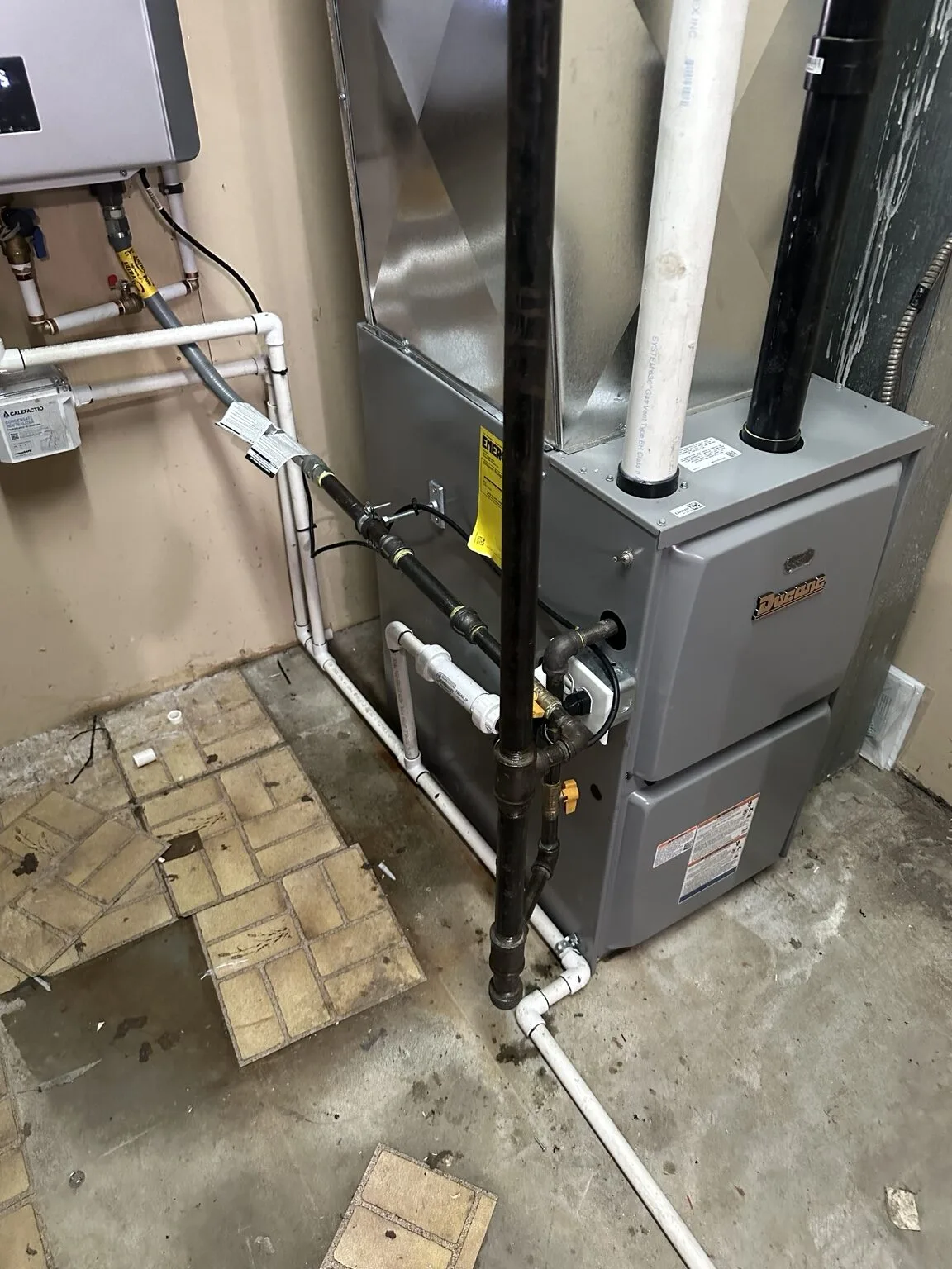 Ducane high-efficiency gas furnace installation with new venting and drain lines.