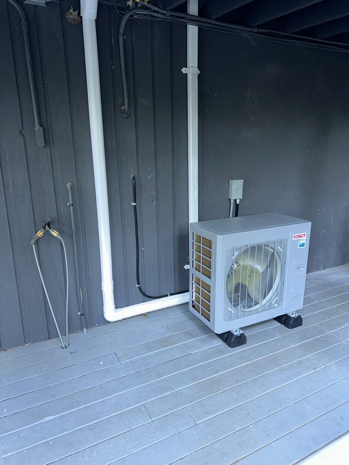 TOSOT ductless mini-split outdoor unit installed on a residential deck.
