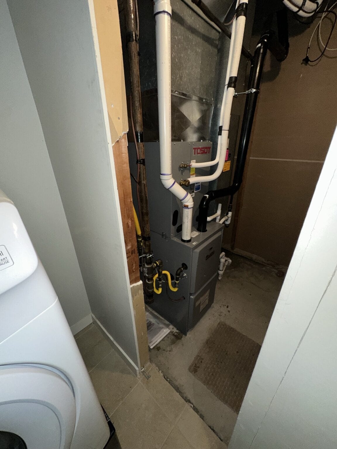 TOSOT furnace and air handler installed in a compact utility closet.