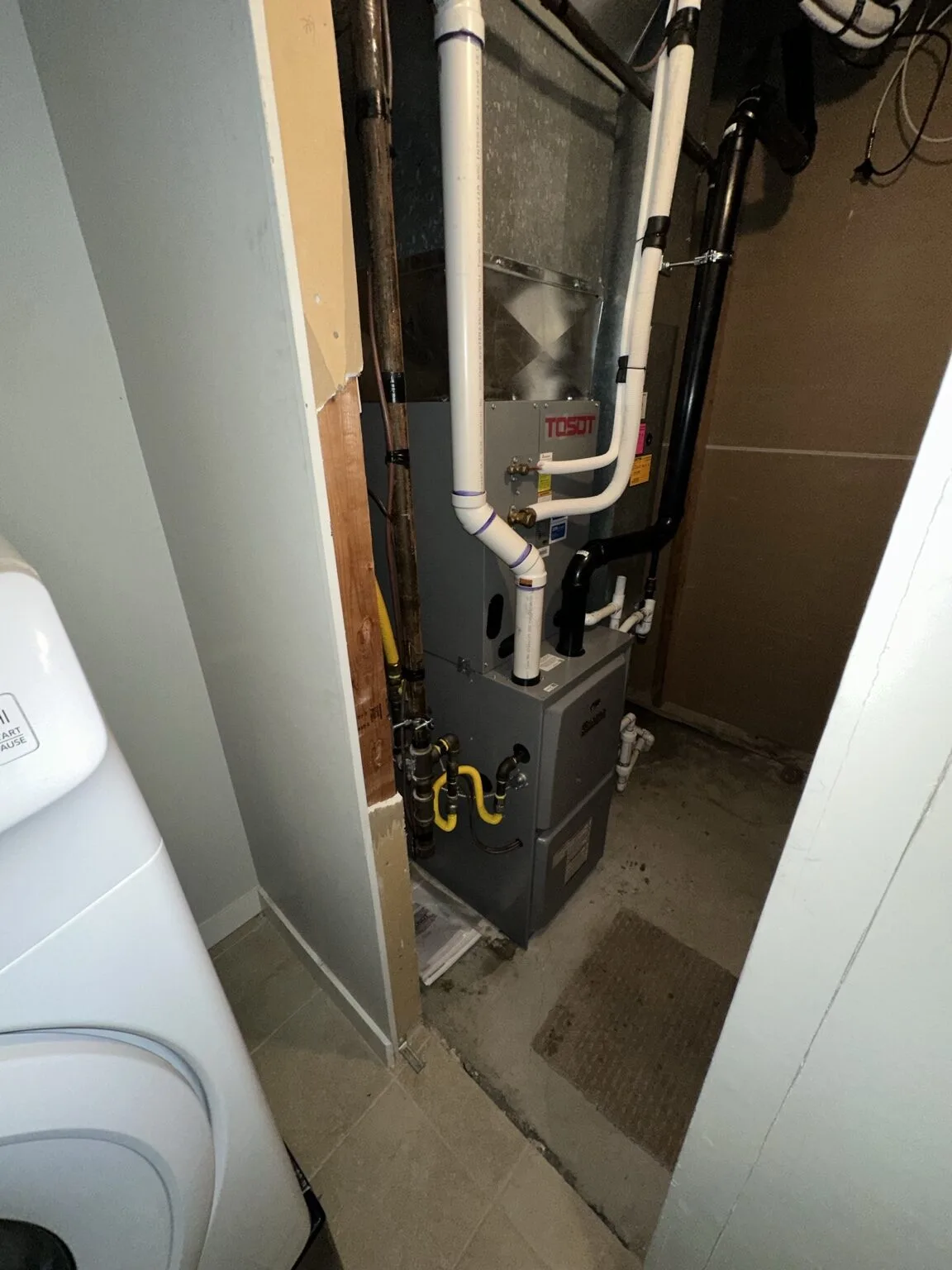TOSOT furnace and air handler installed in a compact utility closet.